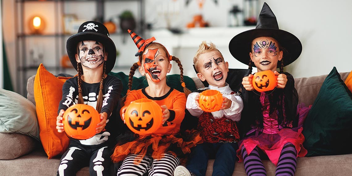 Four kids dressed in Halloween costumes