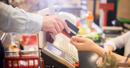 A man handing credit card to checkout clerk